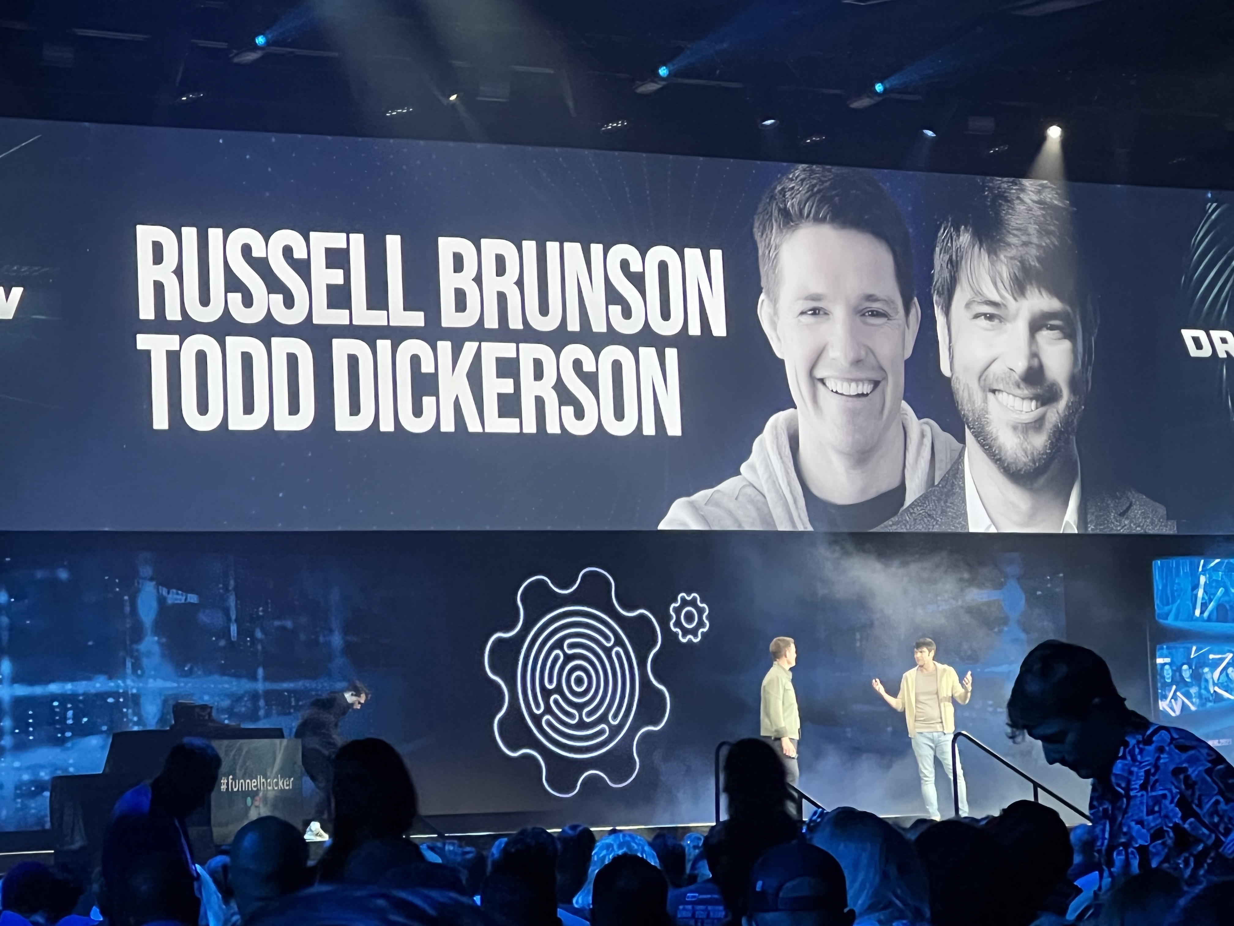 Russell Brunson and Todd Dickerson on stage with a screen advertising them