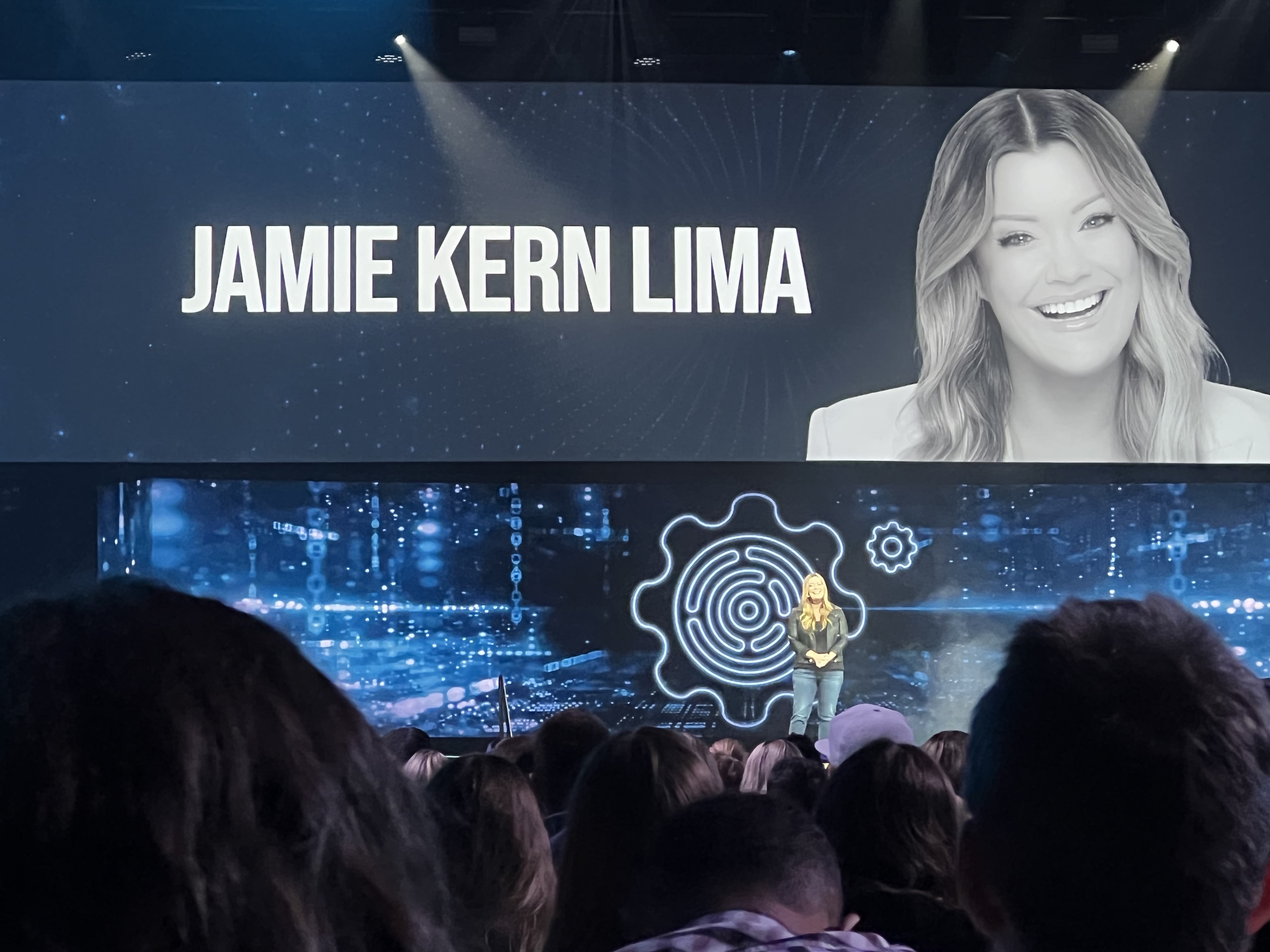 Jamie Kern Lima on stage with a screen advertising her